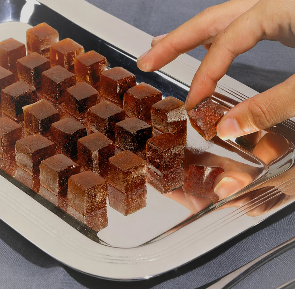 Hand picking a Tempo gummy from a tray